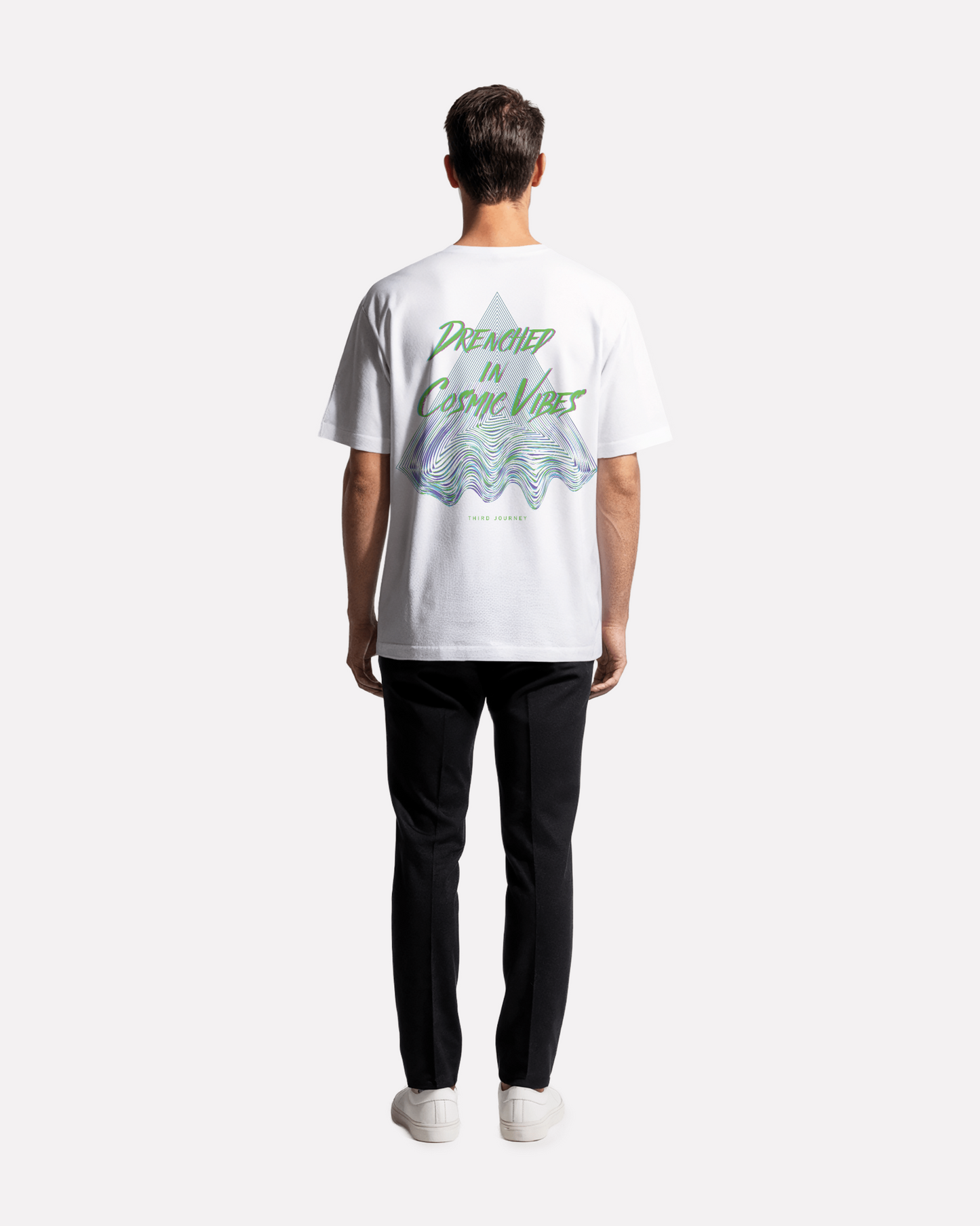 model wearing Third Journey white t-shirt featuring psychedelic triangle graphic and “Drenched in Cosmic Vibes” text in neon green and purple tones