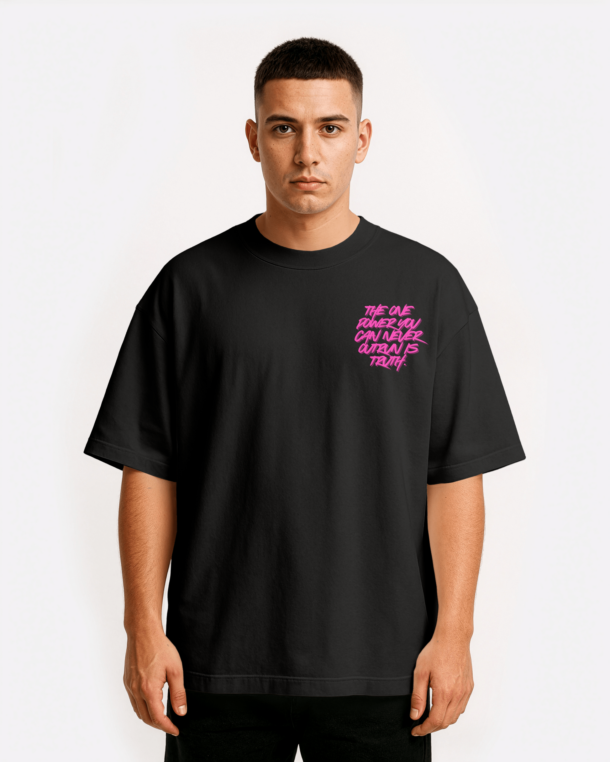 front view of model wearing black Third Journey oversized t-shirt featuring neon pink text reading “The one power you can never outrun is truth”